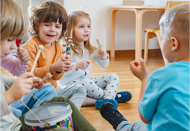 Children playing music with toy instruments, engaging in creative exploration and play-based learning.