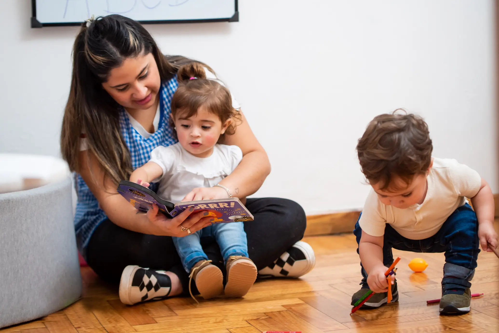 An educator reading a book to a toddler, fostering early literacy skills in a nurturing and engaging learning space.