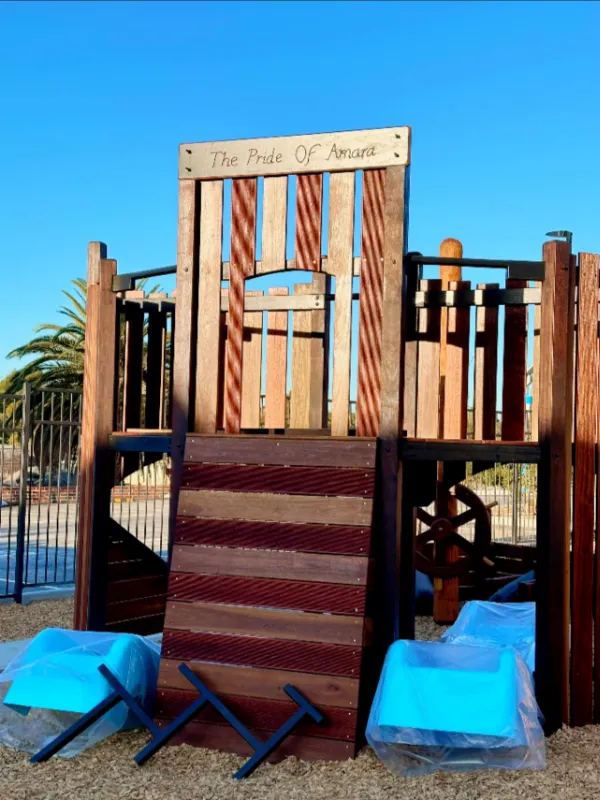 Large wooden climbing structure labelled “The Pride of Amara,” set in a shaded outdoor play area.
