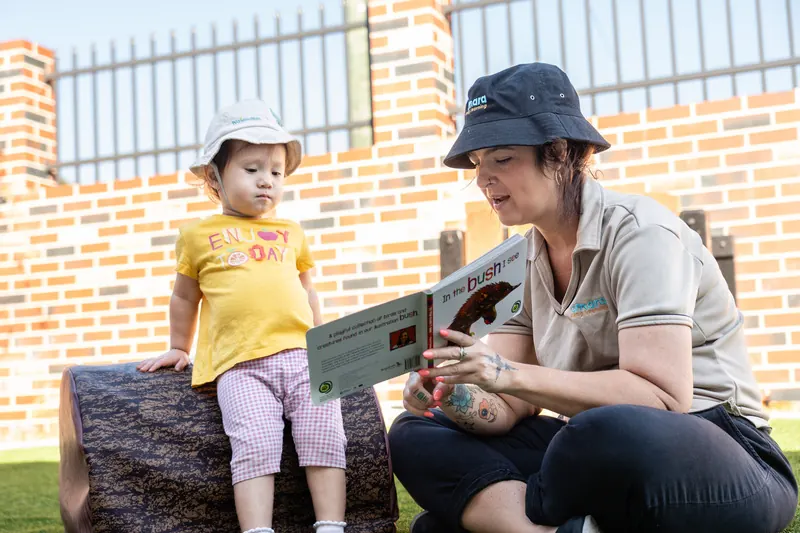 Educator spending time outdoors with a child at Amara.